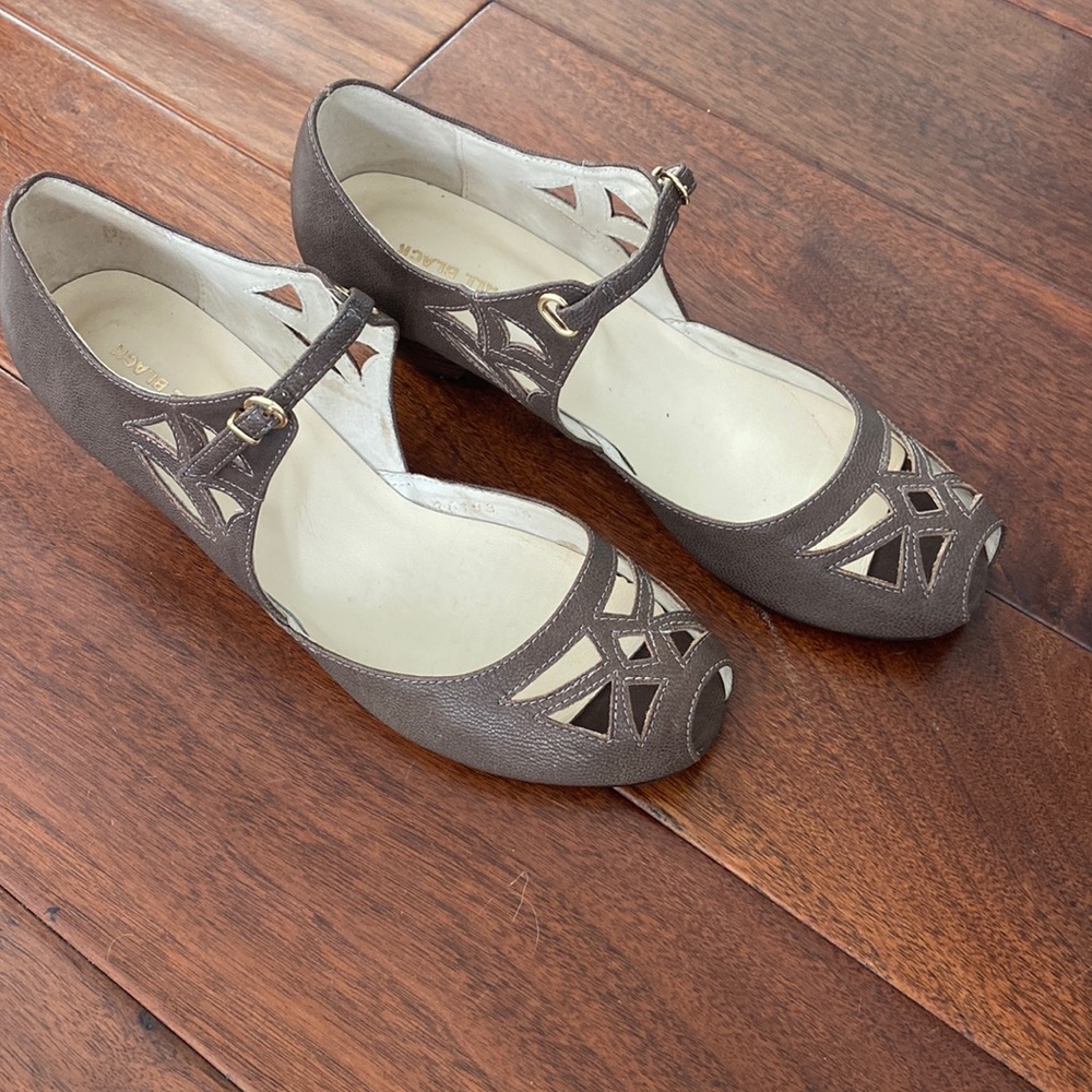 Taupe leather shoes with unique cutouts and adjustable buckle strap.